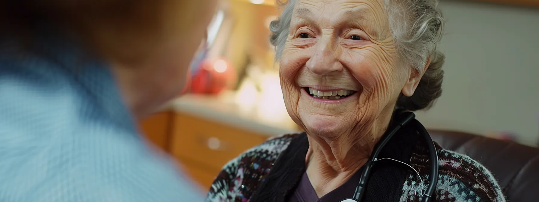 a senior woman smiling while receiving a free preventative screening for colorectal cancer through medicare.